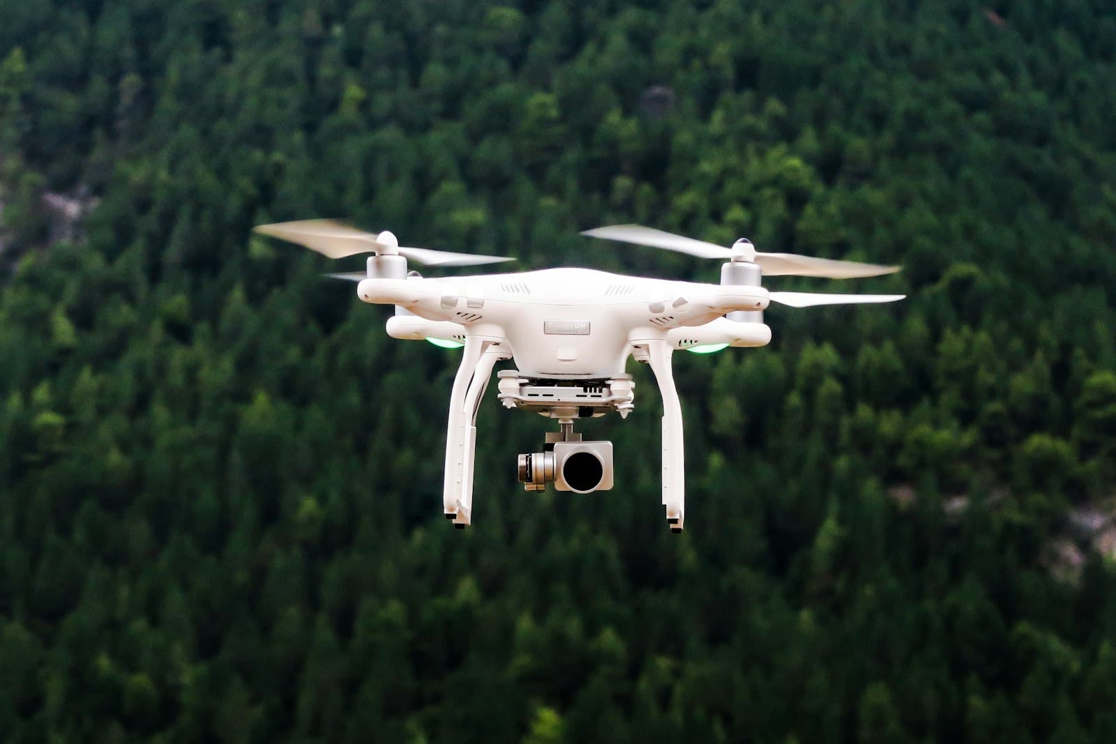 A small multirotor aircraft hovering outdoors against a pale sky.