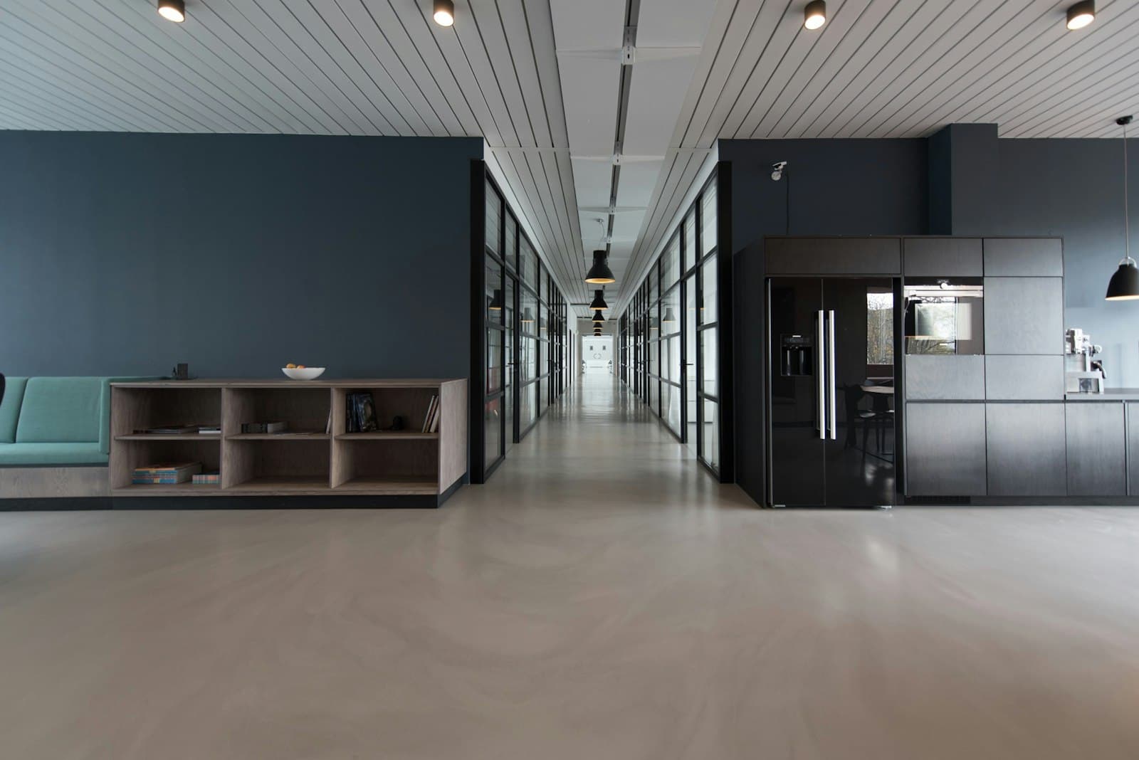 A quiet modern office interior with desks and large windows.